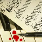 sheet music, pen and blood on piano keyboard