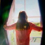 woman looking through curtains